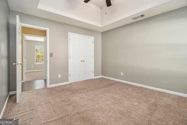 unfurnished bedroom with carpet, a textured ceiling, a closet, and ceiling fan