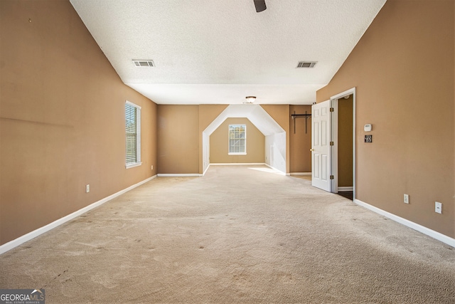 bonus room featuring carpet flooring, lofted ceiling, and a textured ceiling