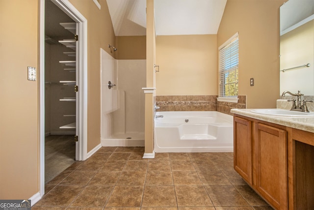 bathroom featuring tile patterned flooring, vanity, plus walk in shower, and vaulted ceiling