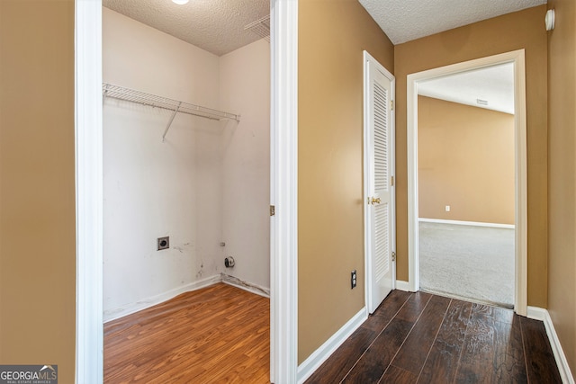 laundry room with dark hardwood / wood-style flooring, a textured ceiling, and electric dryer hookup