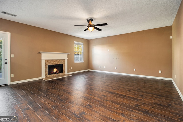 unfurnished living room featuring a textured ceiling, dark hardwood / wood-style flooring, and ceiling fan