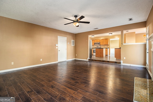 unfurnished living room with a textured ceiling, dark hardwood / wood-style floors, and ceiling fan