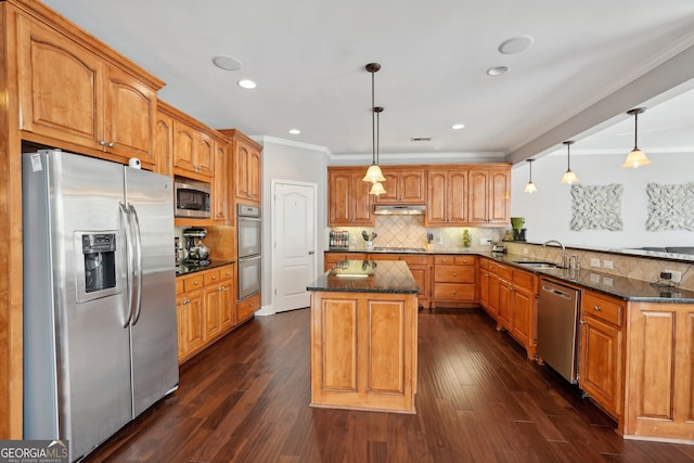 kitchen featuring dark hardwood / wood-style flooring, pendant lighting, stainless steel appliances, and sink