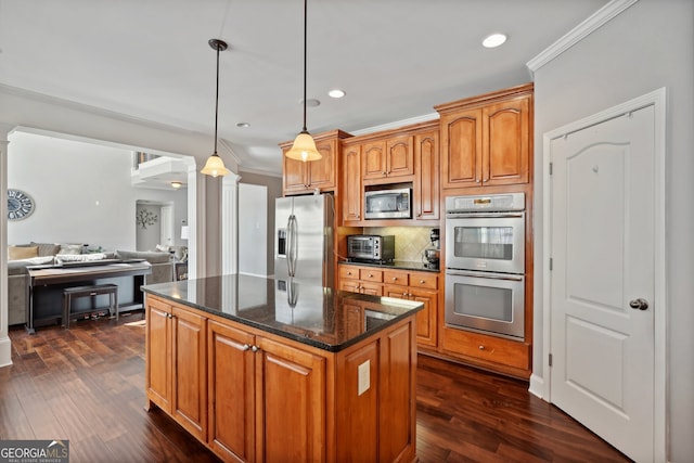 kitchen featuring stainless steel appliances, hanging light fixtures, crown molding, and dark hardwood / wood-style floors