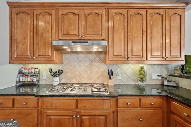 kitchen featuring tasteful backsplash, stainless steel gas stovetop, and dark stone countertops