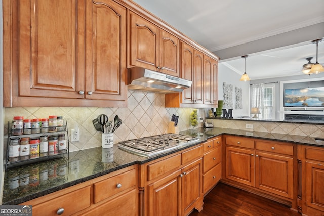 kitchen featuring dark wood-type flooring, tasteful backsplash, decorative light fixtures, stainless steel gas stovetop, and ornamental molding