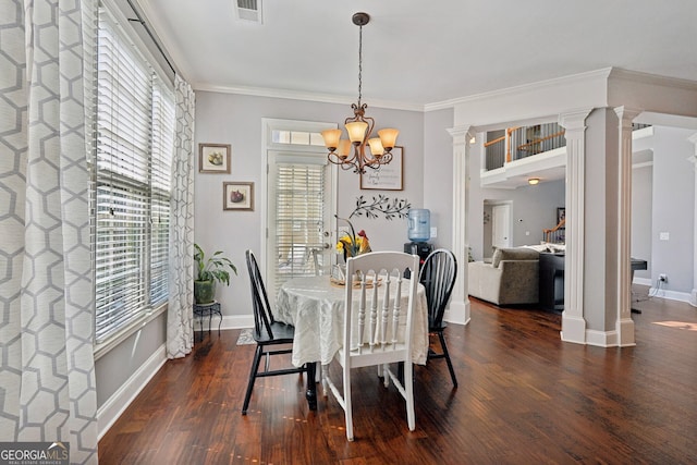 dining space with ornate columns, a notable chandelier, dark hardwood / wood-style floors, and ornamental molding