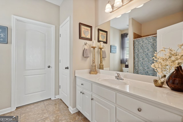 bathroom with tile patterned flooring, vanity, toilet, and walk in shower