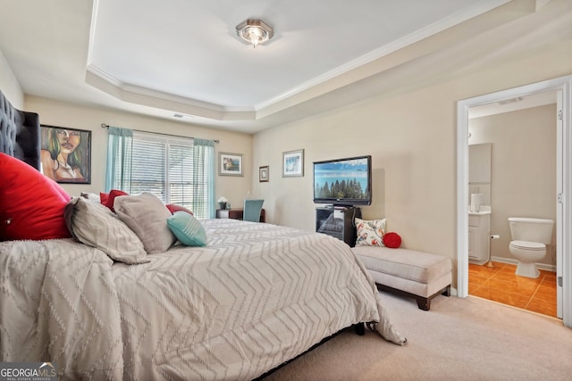 tiled bedroom with ensuite bathroom, a raised ceiling, and ornamental molding