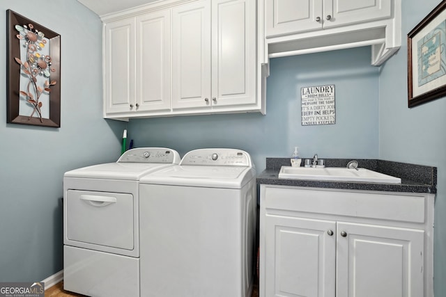 laundry area featuring separate washer and dryer, sink, and cabinets