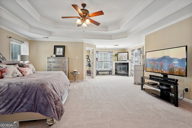 bedroom with light carpet, a raised ceiling, ceiling fan, and crown molding