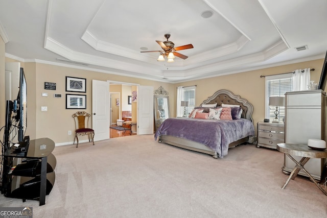 carpeted bedroom with a tray ceiling, ceiling fan, and crown molding