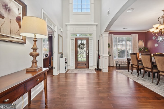 entrance foyer with plenty of natural light, dark wood-type flooring, and an inviting chandelier