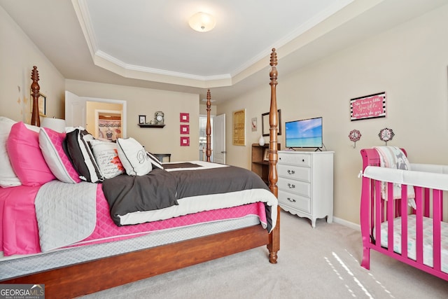 carpeted bedroom with a raised ceiling and crown molding