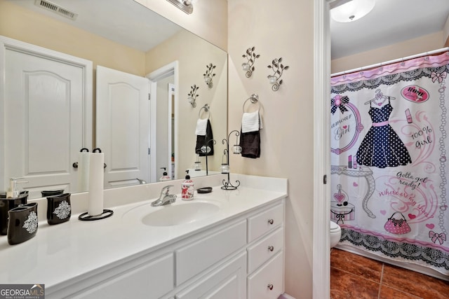 bathroom with tile patterned flooring, a shower with curtain, vanity, and toilet