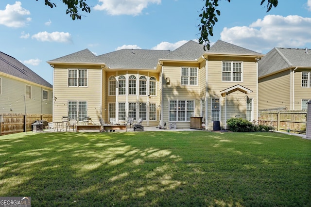 rear view of house featuring a patio area and a yard