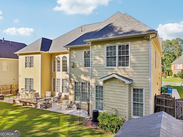 rear view of house with a lawn and a patio