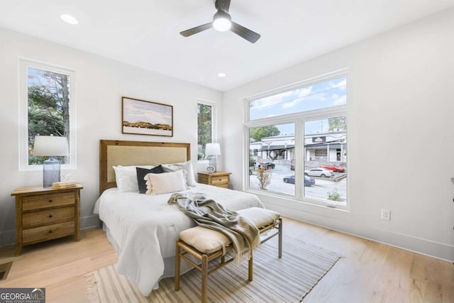 bedroom with light wood-type flooring, multiple windows, and ceiling fan