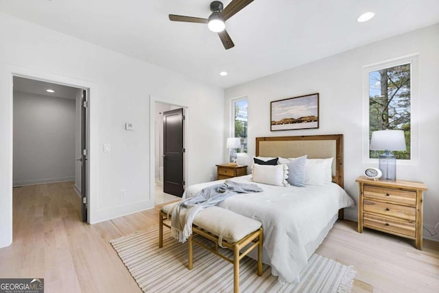 bedroom with connected bathroom, ceiling fan, and light hardwood / wood-style floors