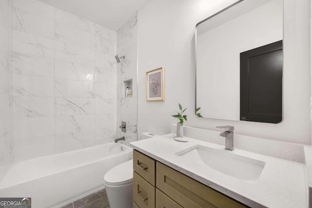 full bathroom featuring vanity, tiled shower / bath, and toilet