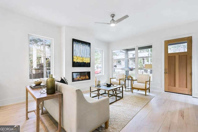 living room featuring light hardwood / wood-style flooring, plenty of natural light, and ceiling fan