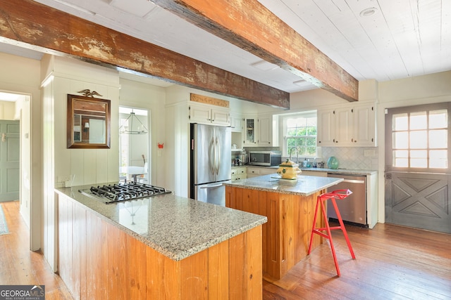 kitchen featuring white cabinetry, light hardwood / wood-style flooring, light stone countertops, and appliances with stainless steel finishes