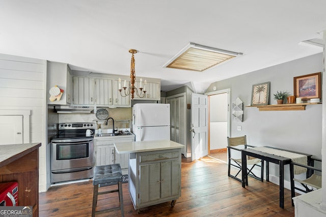 kitchen with stainless steel electric range oven, sink, dark wood-type flooring, white refrigerator, and pendant lighting