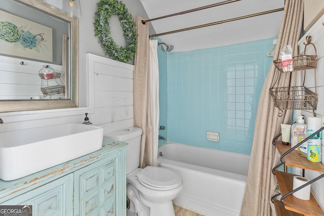 full bathroom with toilet, shower / bathtub combination with curtain, and sink