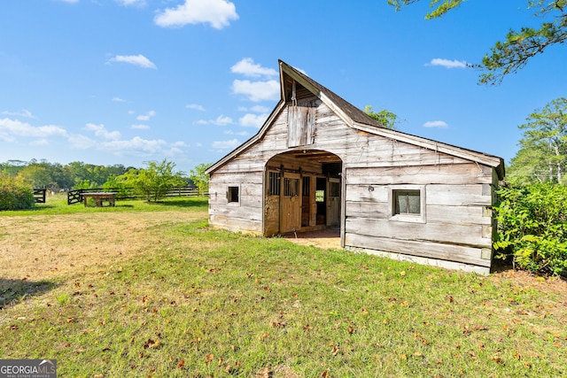 view of outbuilding with a rural view and a lawn