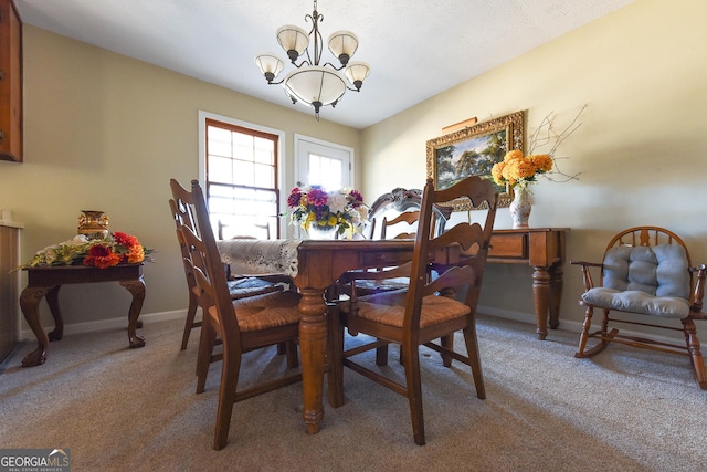 dining space with light carpet, a textured ceiling, baseboards, and an inviting chandelier