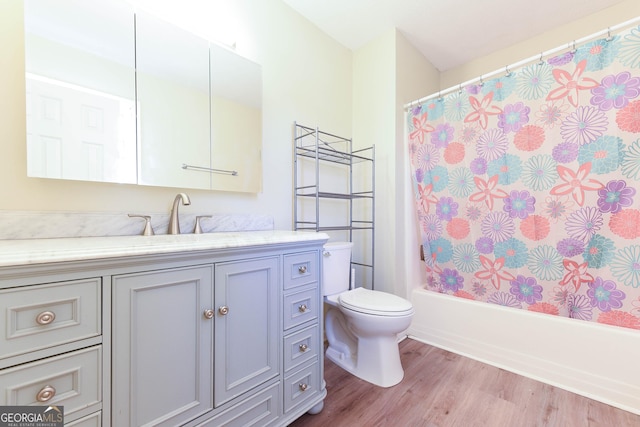 full bathroom featuring toilet, shower / bath combination with curtain, wood finished floors, and vanity