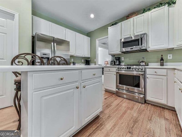 kitchen with white cabinetry, light hardwood / wood-style floors, and appliances with stainless steel finishes