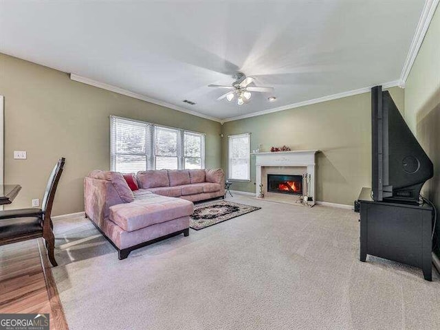 living room featuring light colored carpet, ceiling fan, and crown molding