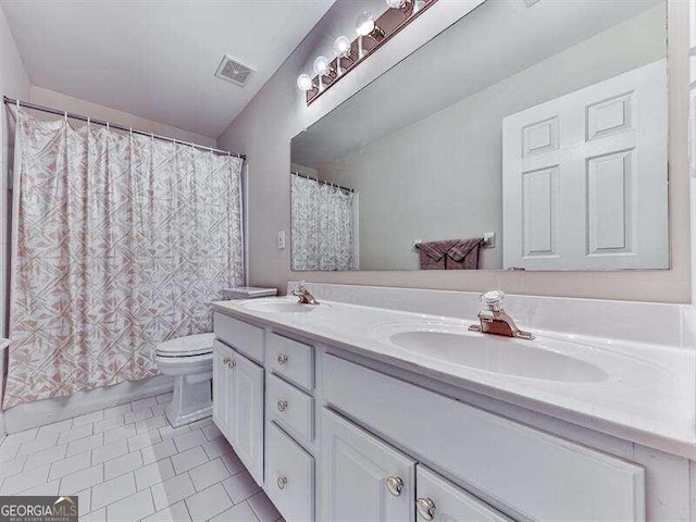 bathroom featuring tile patterned floors, vanity, and toilet