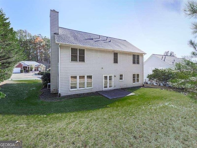 back of property featuring a yard, french doors, and a patio