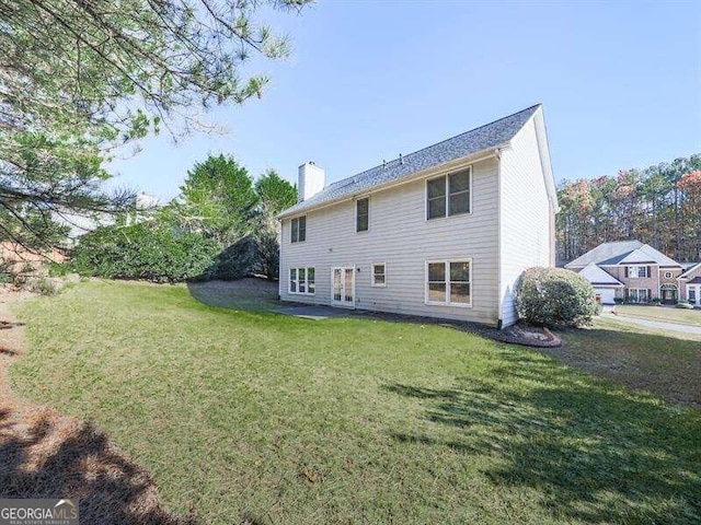 back of house featuring a lawn and french doors