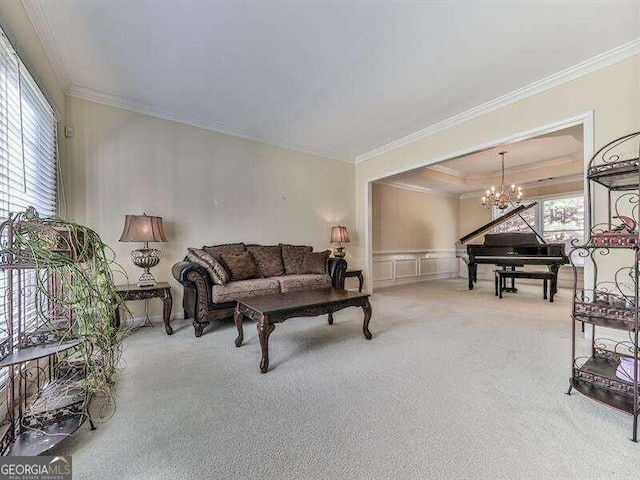 living room featuring an inviting chandelier, carpet floors, and ornamental molding