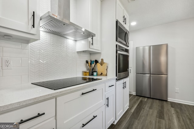 kitchen with white cabinetry, dark hardwood / wood-style flooring, wall chimney exhaust hood, and appliances with stainless steel finishes