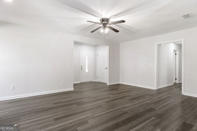 unfurnished living room featuring dark hardwood / wood-style floors, ceiling fan, and a textured ceiling