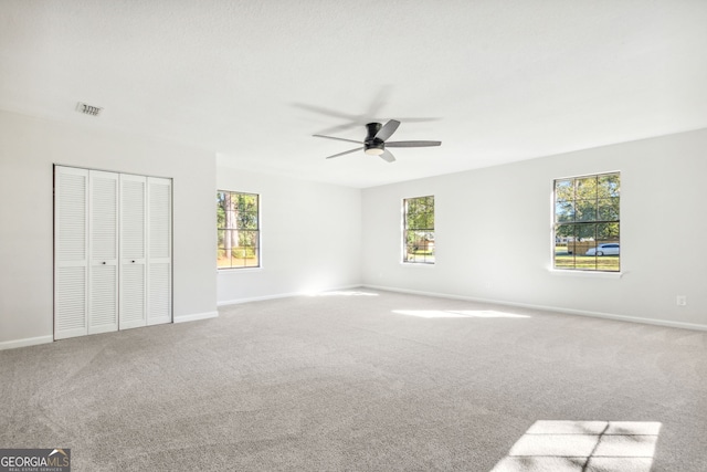 unfurnished bedroom with multiple windows, ceiling fan, and carpet