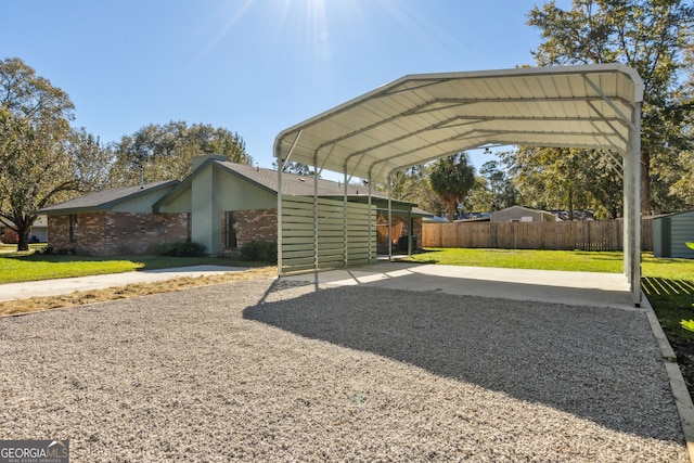 view of parking / parking lot featuring a lawn and a carport