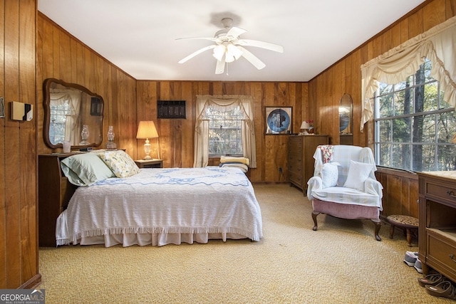 bedroom featuring ceiling fan, wooden walls, and multiple windows