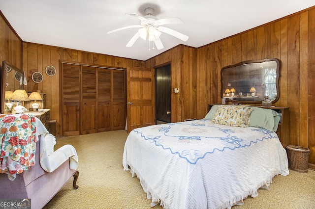 bedroom with carpet flooring, a closet, ceiling fan, and wooden walls