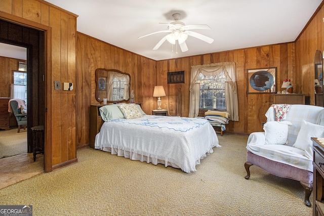 bedroom with carpet flooring, ceiling fan, and wooden walls