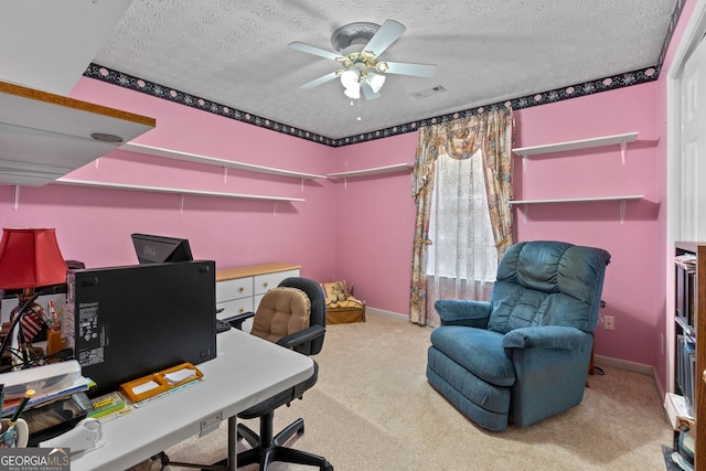 carpeted home office with ceiling fan and a textured ceiling