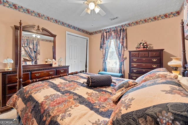 carpeted bedroom with ceiling fan, a textured ceiling, and a closet