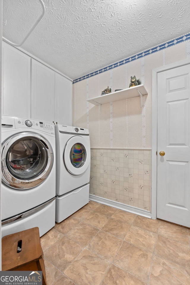 washroom with washing machine and dryer and a textured ceiling