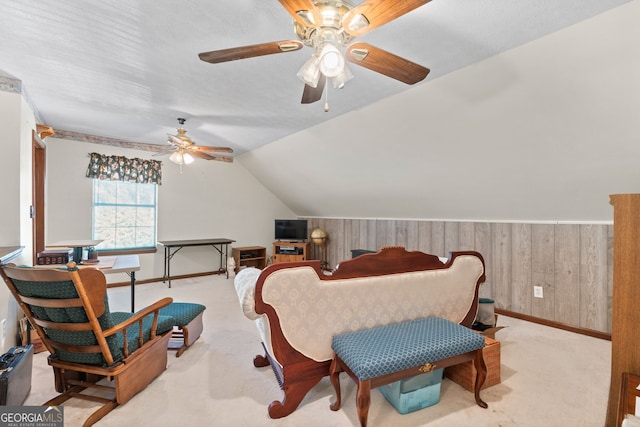 carpeted bedroom with vaulted ceiling, ceiling fan, and wood walls