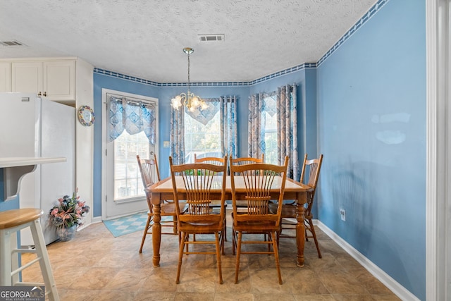 dining space featuring a textured ceiling and an inviting chandelier