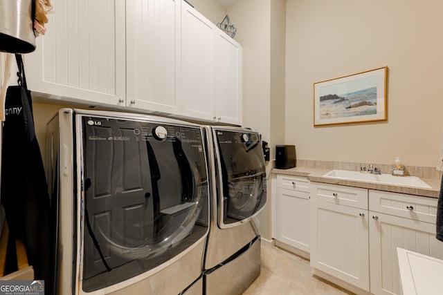 laundry area featuring cabinets, light tile patterned flooring, washing machine and dryer, and sink